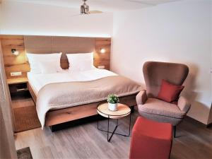 埃登科本普法尔茨餐厅酒店的配有一张床和一把椅子的酒店客房
