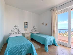 内比达Splendida vista sul mare的海景卧室内的两张床