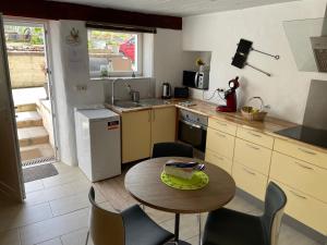 ScheidgenLe Potiron的厨房配有桌椅和水槽。