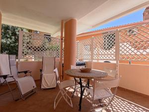 内比达Splendida vista sul mare的阳台的天井配有桌椅