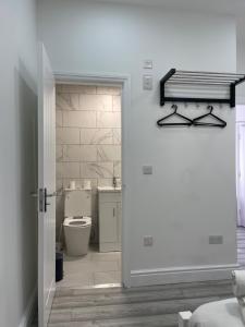伦敦EAST LONDON APARTMENTS SELF check in的通往带卫生间的浴室的开放式门