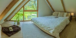 博维茨Tiny Eko House Bovec的一间卧室设有一张床和一个大窗户