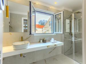 斯普利特Irini Luxury Rooms的一间带水槽和玻璃淋浴的浴室