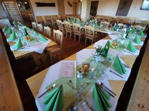 默尼希基兴Alpengasthof Fernblick的一组配有绿色餐巾和银器的桌子