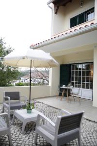 奥比多斯Casa Do Shon的庭院配有桌椅和遮阳伞。