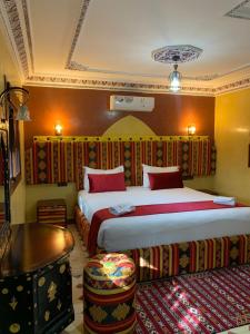 瓦尔扎扎特Dar Alfourssane Ferme d’hôte的酒店客房设有两张床和一张桌子。