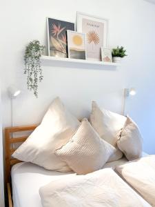 梅明根NAMI - ROBIN - Helle Apartments mitten in der Stadt的卧室配有带白色枕头和架子的床