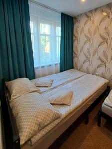 密古雷休治7 Levél Central Apartments的卧室内的一张床位,配有绿色窗帘和窗户