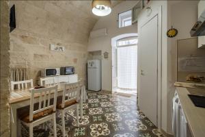 滨海波利尼亚诺Chiarina rooms 2的一间带桌子和冰箱的小厨房