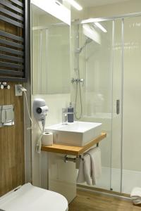 拉辛Hotel Parrot的浴室配有白色水槽和淋浴。