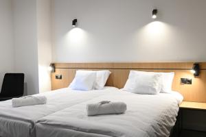 拉辛Hotel Parrot的一间卧室配有两张带白色枕头的床