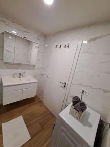 木洛希尼Apartman Tea的带淋浴和盥洗盆的白色浴室