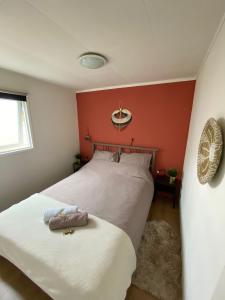 安卢Woodz Aan de bosrand的一间卧室设有两张床和红色的墙壁