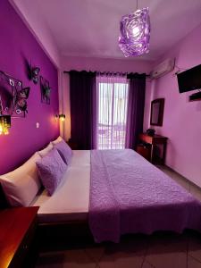 巴利恩贝拉维斯塔酒店的紫色卧室设有一张带紫色墙壁的大床