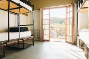 圣马丁德洛斯Bike Hostel的客房设有两张双层床和大窗户。