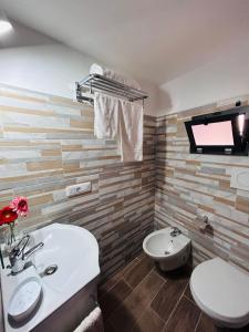 切列梅萨皮卡Le Camere Dei Mascia的一间带水槽和卫生间的浴室以及一台电视。