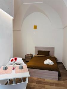 切列梅萨皮卡Le Camere Dei Mascia的一间卧室配有一张床和一张桌子及两把椅子
