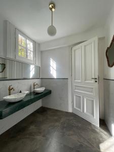 蒂格雷Casa Villa Julia的一间带两个水槽和白色门的浴室