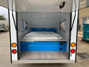 金德拜恩Jindabyne caravan hire的蓝色和白色面包车后面的一张床位