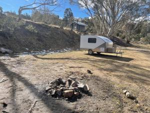 金德拜恩Jindabyne caravan hire的停在一堆岩石旁的白色拖车