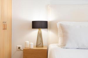 奈德里Adria Luxury Apartments的一间卧室,配有一张带台灯的床头柜