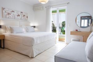 奈德里Adria Luxury Apartments的白色卧室设有一张大床和镜子