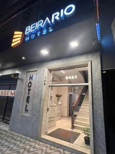 特奥菲卢奥托尼Hotel Beira Rio的门上标有标志的商店入口