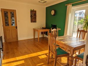 锡德茅斯Pipers Hill的一间设有木桌和绿色墙壁的用餐室
