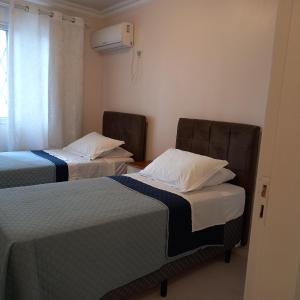 克里西玛Espaço aconchegante em Criciúma的客房设有两张床和窗户。