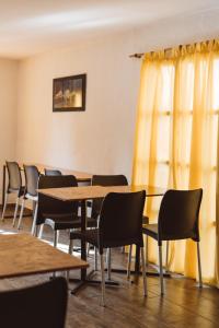 埃尔卡拉法特Hostel House 64Bigüa的有一排桌子和椅子,位于一间黄色窗帘的房间