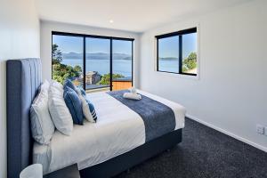 惠灵顿Brand New with Ocean Views的一间卧室设有一张大床和大窗户