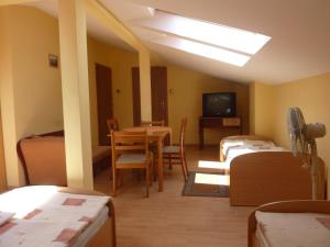 罗兹扎亚兹阿尔卡酒店的客房设有床、桌子和电视。