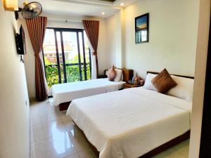 归仁LaCas Hotel Quy Nhon的酒店客房设有两张床和一个阳台。