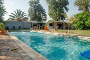 拉班达Complejo Mis Pumitas的一个带椅子的游泳池以及一座房子