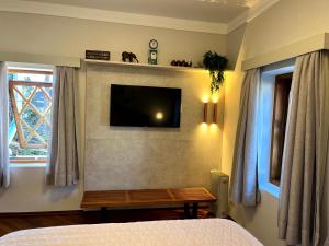 坎波斯杜若尔当Flat Centro de Capivari的卧室配有带桌子的墙上电视