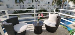阿卡普尔科Departamento Confortable y Moderno en Acapulco Diamante的一个带桌椅的阳台和一个游泳池
