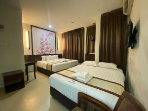 瑟纳旺D&F BOUTIQUE HOTEL SENAWANG的酒店客房配有两张床和一张书桌