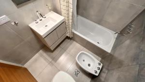 莫龙machado apartamentos moron的浴室配有卫生间、盥洗盆和浴缸。