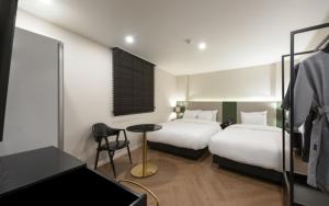 釜山Hotel Yaja Gwangalli的酒店客房配有两张床和一张书桌