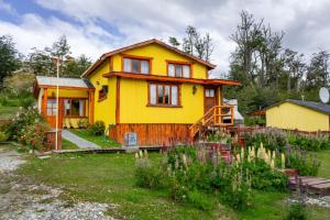 托尔胡因Cabañas Posada de las Flores的黄色的房子,前面有一个花园