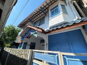 SentoolSinggah Macanan的一座房子,上面有蓝色的门和旗帜