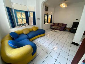 SentoolSinggah Macanan的客厅配有黄色和蓝色的沙发