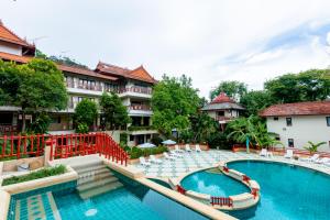 奥南海滩Ao Nang Bay Resort的一个带椅子的度假村游泳池和一个游泳池