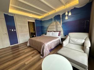 Dali嵩夏汽车旅馆的一间卧室配有一张床、一张沙发和一把椅子