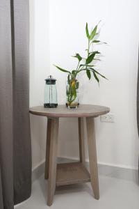 珀拉什奇亚The Ellysian Apartments的花瓶上木桌,上面有植物