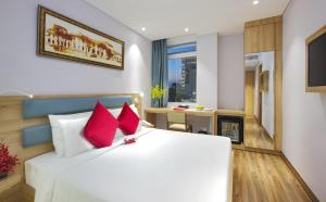 胡志明市RAMADA ENCORE BY WYNDHAM SAIGON D1 - Formerly M Boutique Hotel Saigon的卧室配有带红色枕头的大型白色床