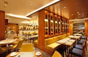 雅加达旁多克英达瑞士贝尔酒店国际的一间带桌椅的餐厅和一间酒吧