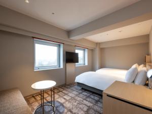 秋田ANA Crowne Plaza Akita, an IHG Hotel的酒店客房配有一张床铺和一张桌子。