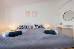 奥米沙利APARTMANI BEBA的一间卧室配有一张大床和两个蓝色枕头