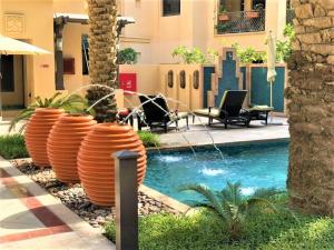 迪拜Stunning Apt with Spacious Terrace Old Town Dubai的一座游泳池,旁边是一座橘子桶